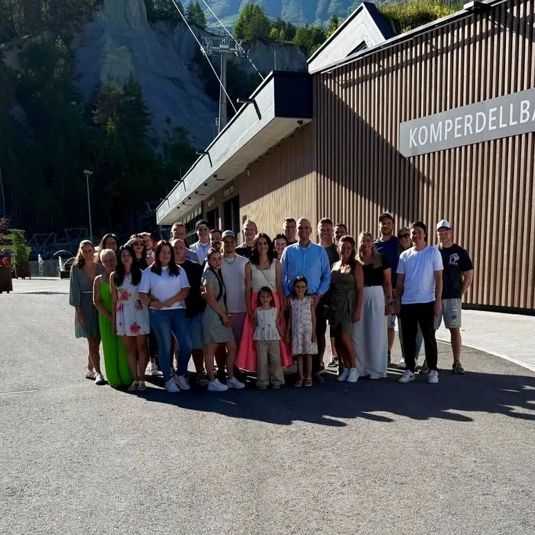 Eine Gruppe von Leuten aus Köhles Spitzenteam posiert an einem sonnigen Tag vor der KOMPERDELLBAHN.